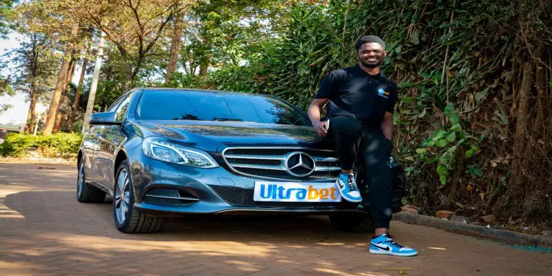 Seth Oluoch poses with Ultra Bet’s Mercedes Benz after winning Ksh56,000 in a multi-bet.